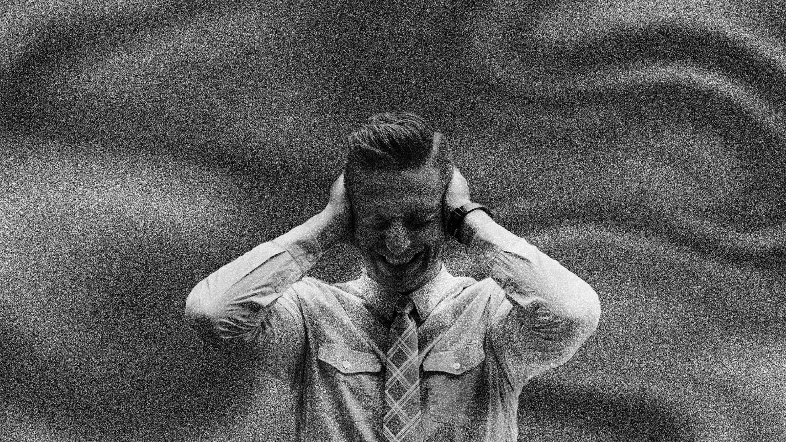 Imagen en blanco y negro con textura granulada de un hombre con camisa y corbata cubriéndose los oídos con ambas manos y cerrando los ojos.