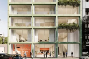 Fachada moderna del Edificio Moncayo con estructura de cuadrícula verde, balcones con vegetación, en la planta baja con peatones circulando.